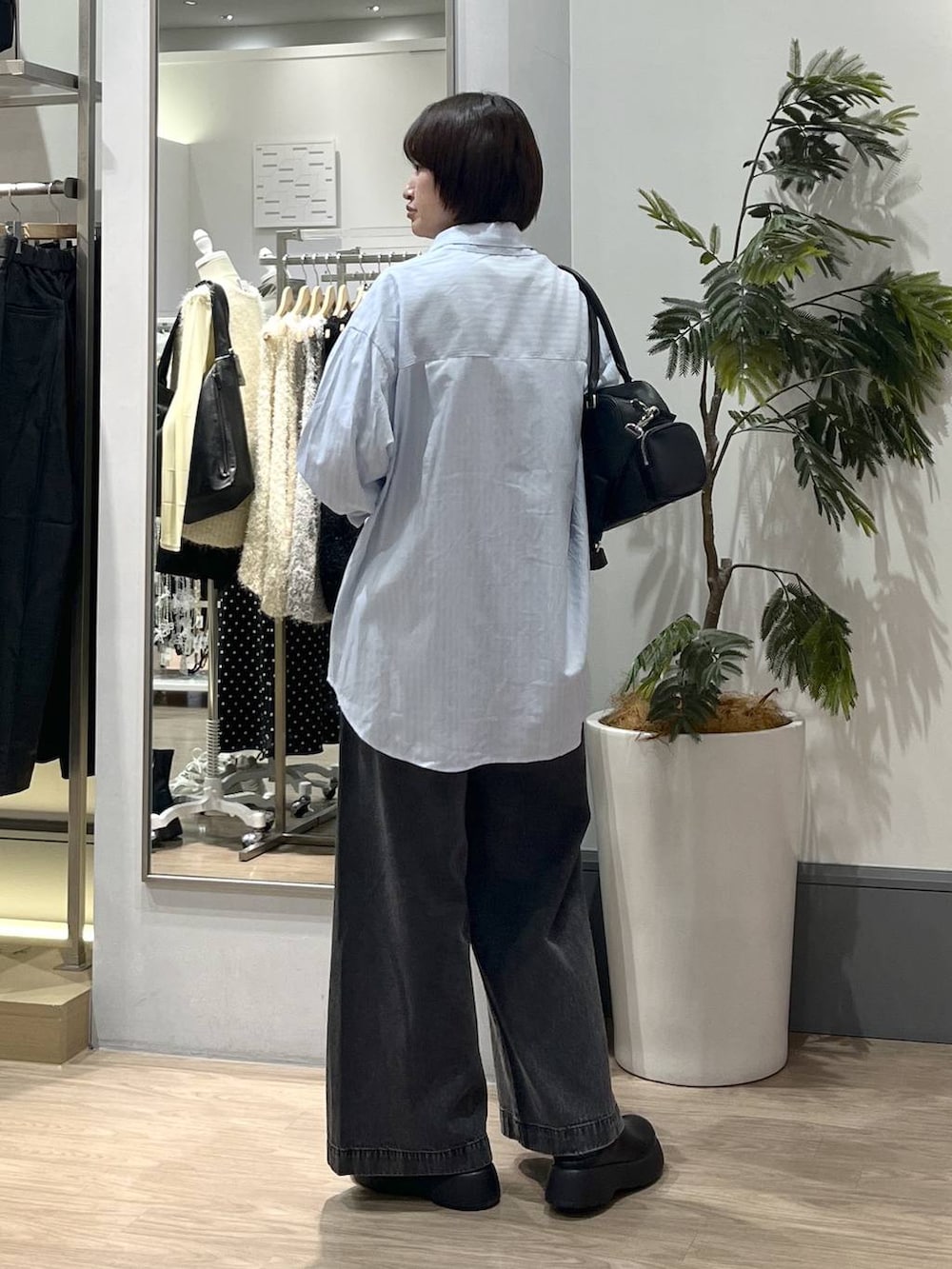 ブラック系のデニムパンツ、ブラック系のボストンバッグ、ブラック系のサンダルを着用したレディースの冬コーディネートの4枚目の写真