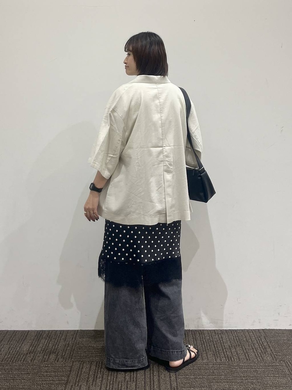 ブラック系のデニムパンツ、ホワイト系のテーラードジャケット、ホワイト系のTシャツ/カットソーを着用したレディースの夏コーディネートの4枚目の写真