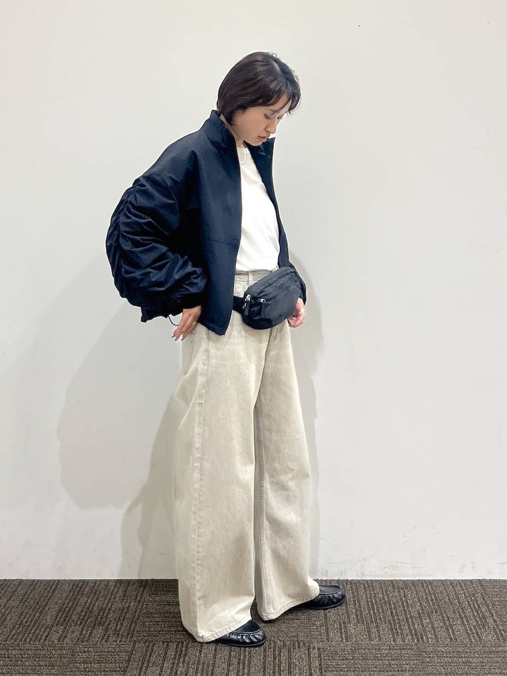 ホワイト系のTシャツ/カットソー、ベージュ系のデニムパンツ、ブラック系のボディバッグ/ウエストポーチを着用したレディースの春コーディネートの3枚目の写真