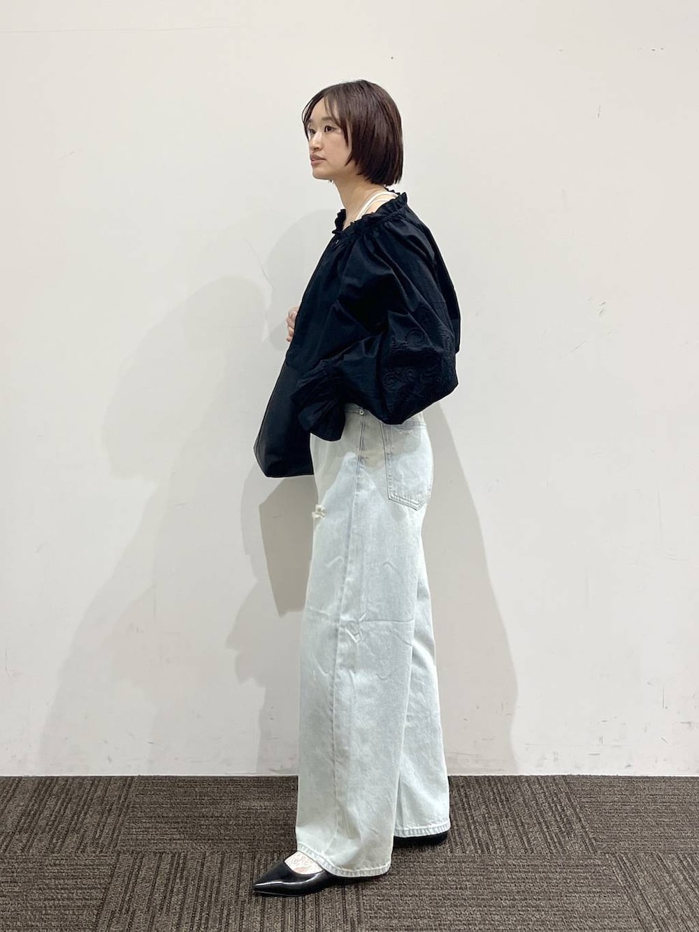 ホワイト系のTシャツ/カットソー、ブラック系のショルダーバッグ、ブラック系のパンプスを着用したレディースの春コーディネートの4枚目の写真