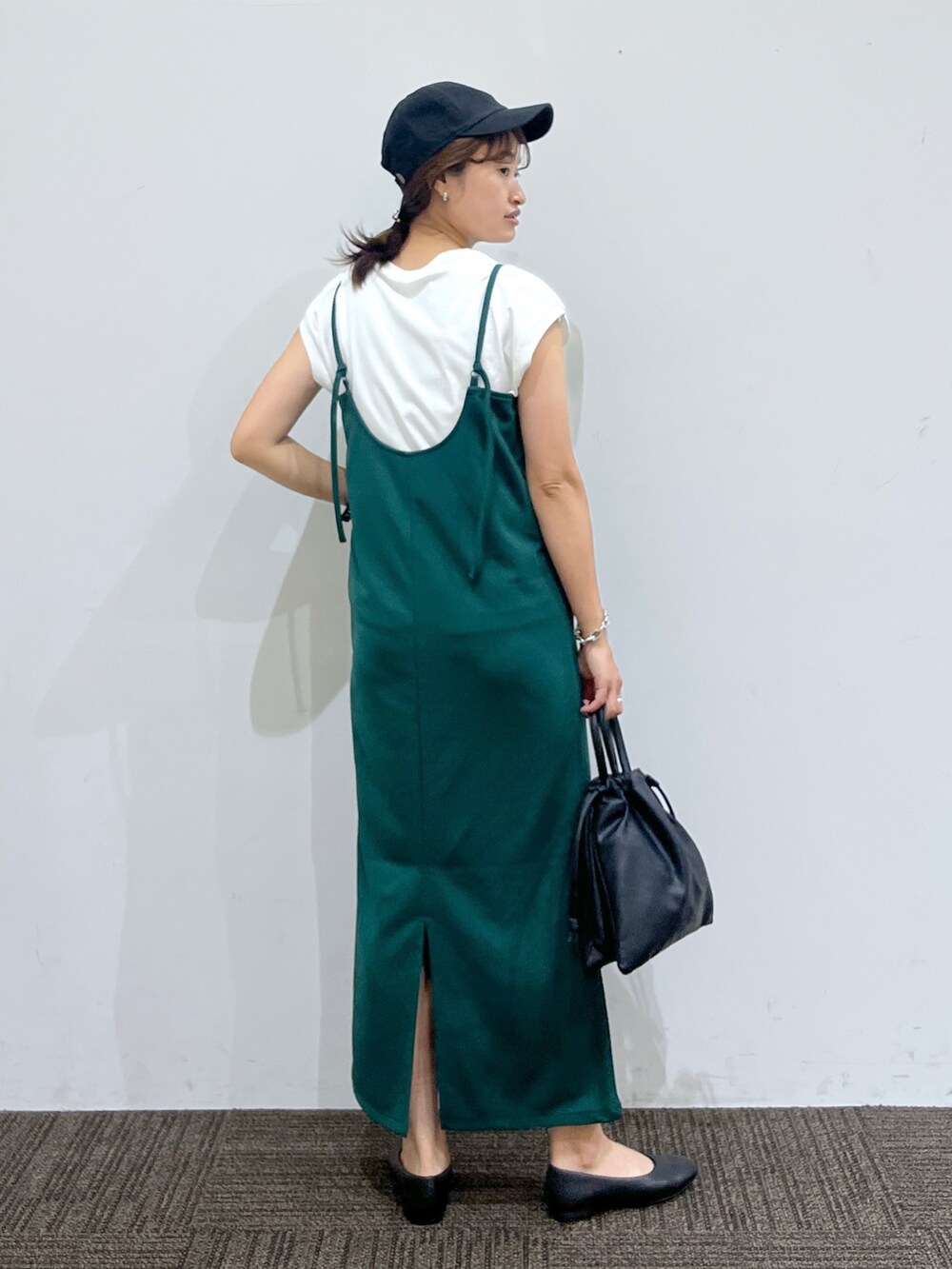 グリーン系のワンピース、ホワイト系のTシャツ/カットソー、ブラック系のショルダーバッグを着用したレディースの夏コーディネートの3枚目の写真