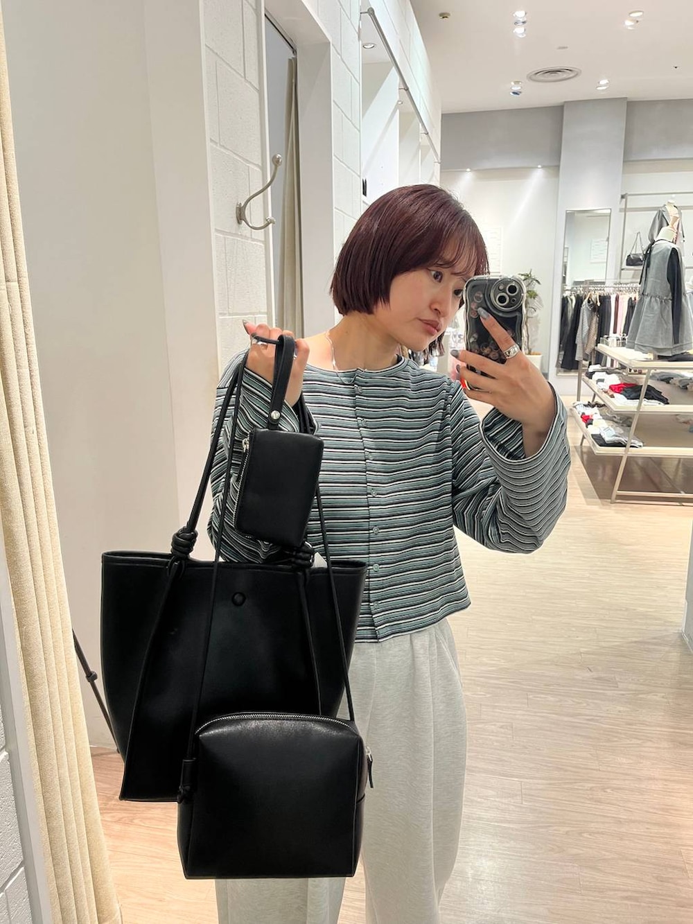 グレー系のスウェットパンツ、ブラック系のトートバッグ、グリーン系のカーディガン/ボレロを着用したレディースの春コーディネートの2枚目の写真