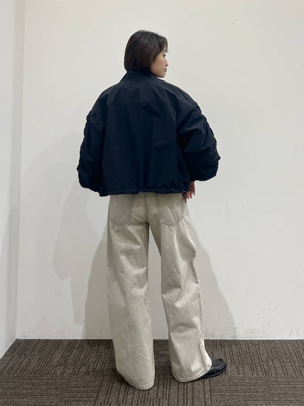 ホワイト系のTシャツ/カットソー、ベージュ系のデニムパンツ、ブラック系のボディバッグ/ウエストポーチを着用したレディースの春コーディネートの4枚目の写真