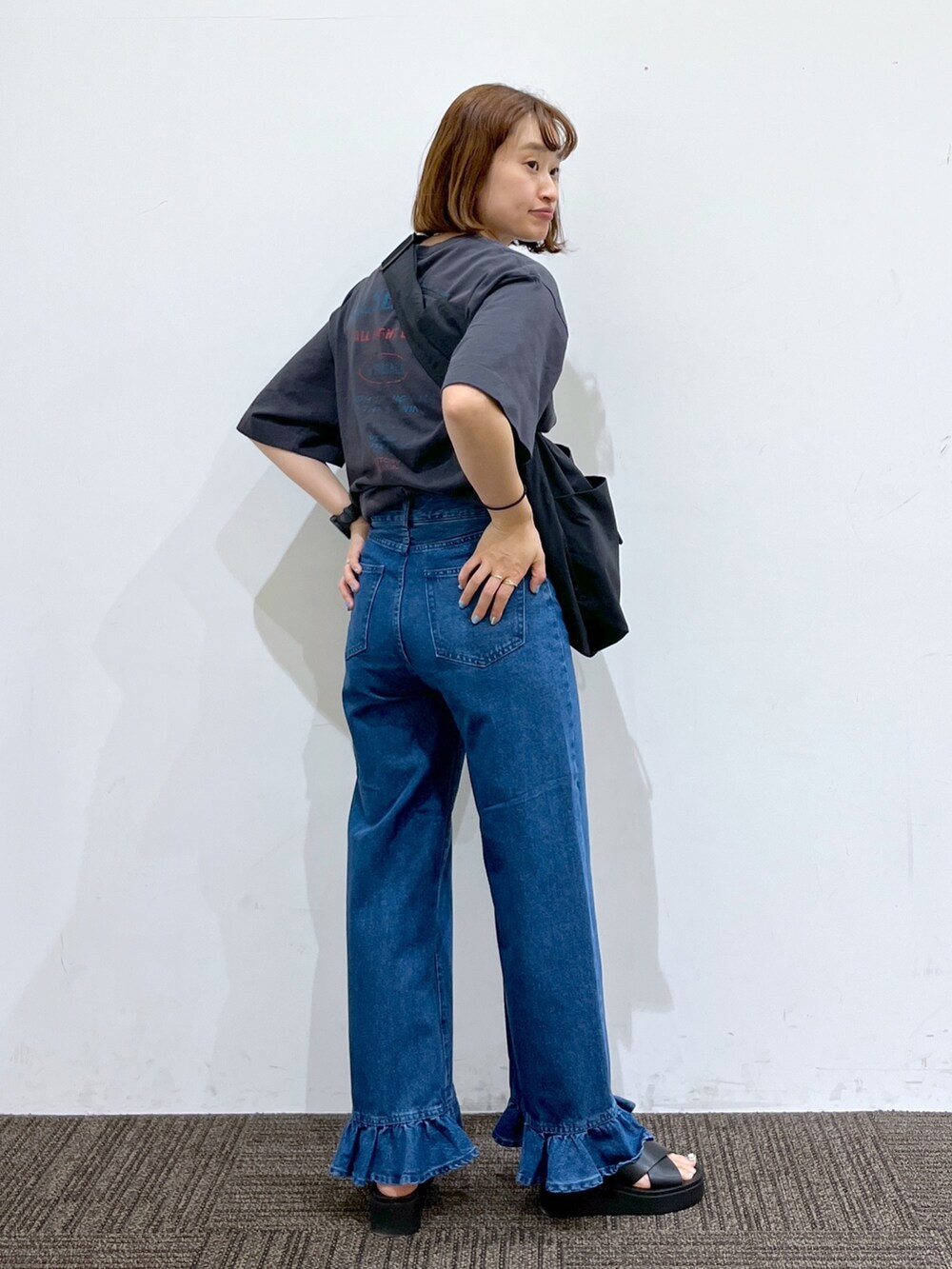 ブルー系のデニムパンツ、グレー系のTシャツ/カットソー、ブラック系のバッグを着用したレディースの春コーディネートの3枚目の写真