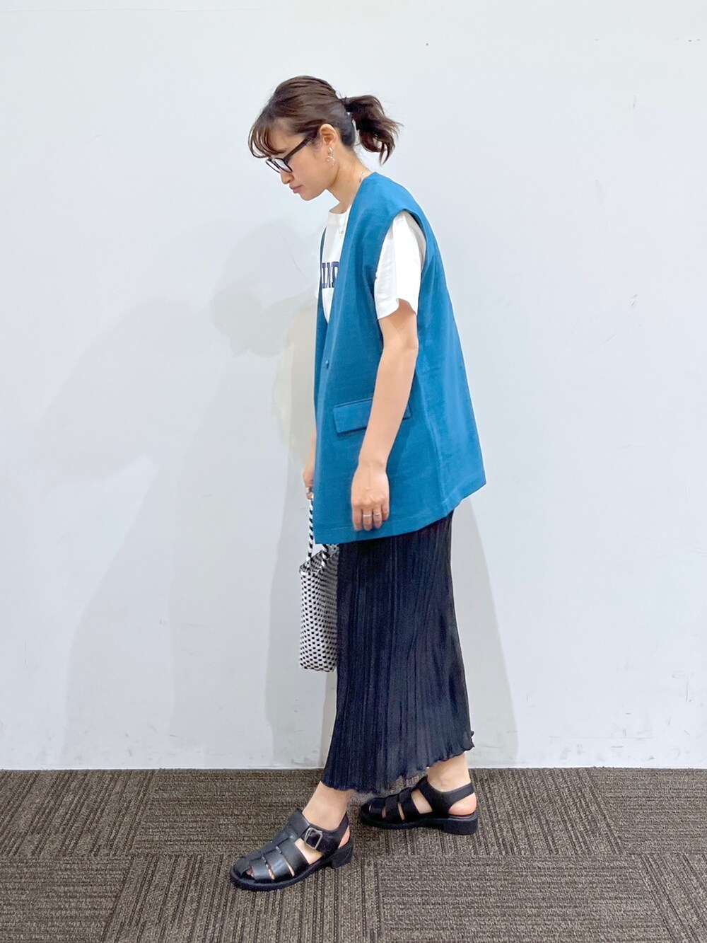 ブラック系のサンダル、ブラック系のスカート、ブラック系のかごバッグを着用したレディースの春コーディネートの2枚目の写真