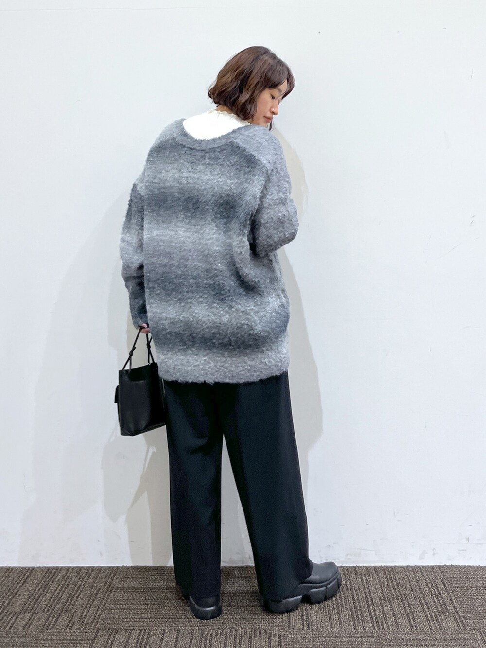 ホワイト系のニット/セーター、ブラック系のトップス、ブラック系のパンツを着用したレディースの冬コーディネートの3枚目の写真