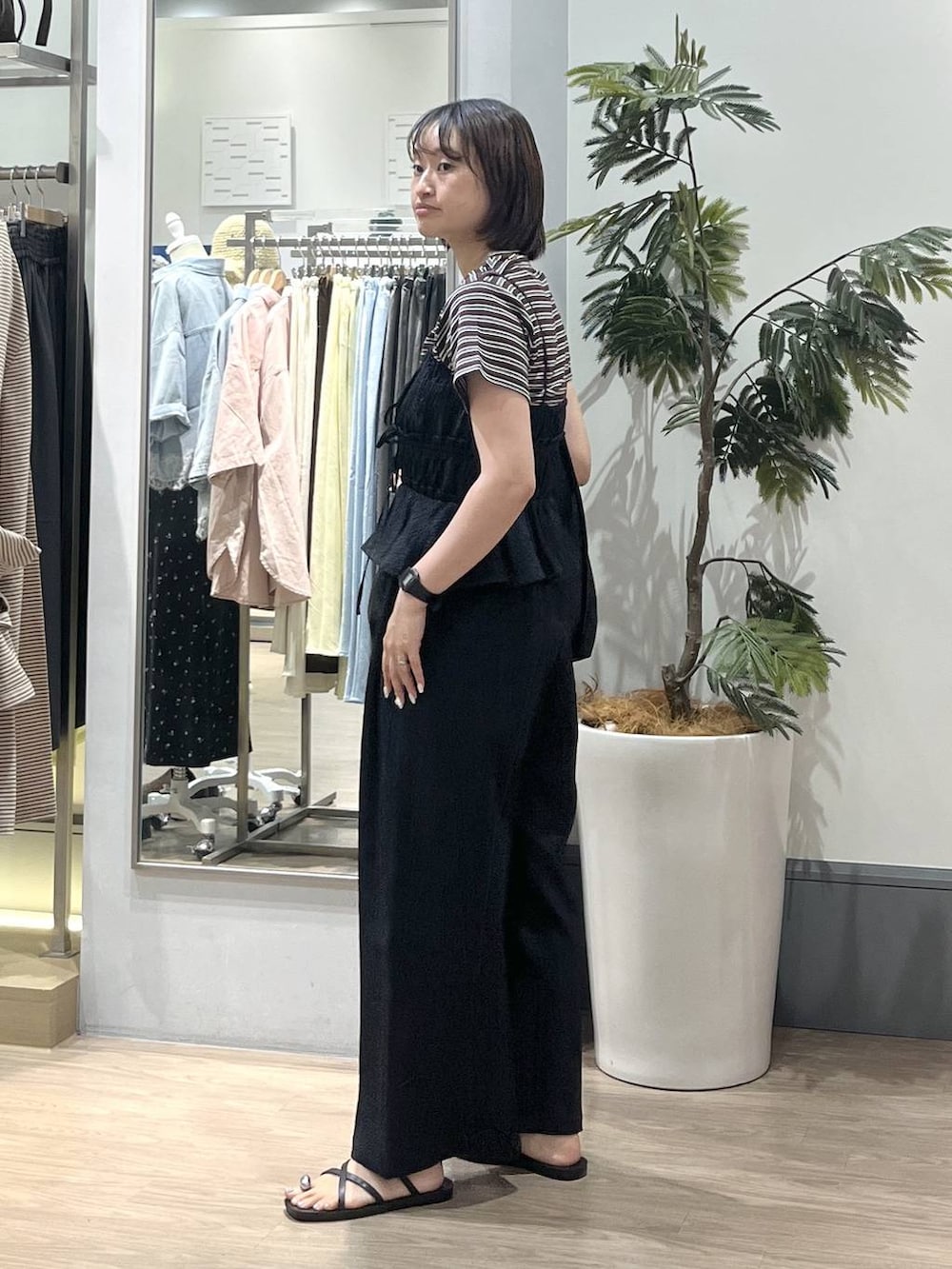 ブラック系のショルダーバッグ、ブラウン系のTシャツ/カットソー、ブラック系のサロペット/オーバーオールを着用したレディースの夏コーディネートの2枚目の写真