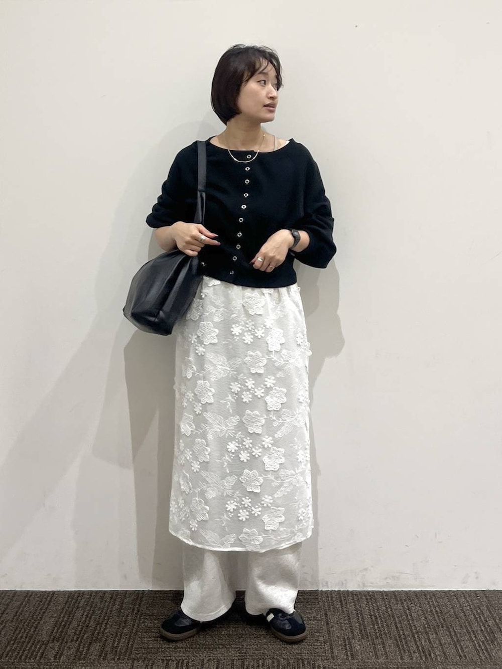 ブラック系のショルダーバッグ、グレー系のスウェットパンツ、ホワイト系のスカートを着用したレディースの春コーディネートの3枚目の写真