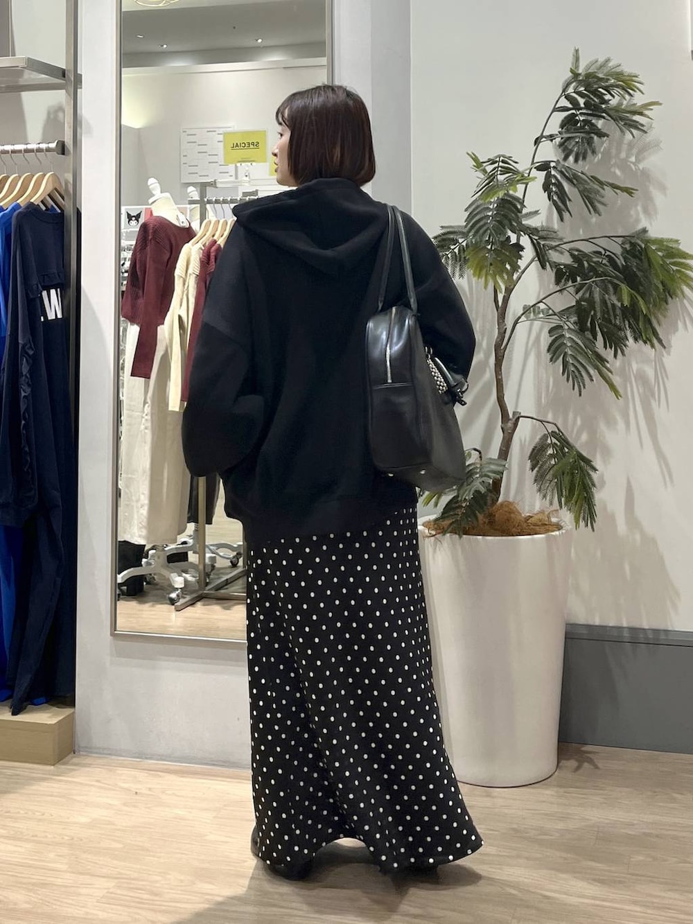 ブラック系のスカート、ブラック系のパーカー、ホワイト系のTシャツ/カットソーを着用したレディースの秋コーディネートの4枚目の写真