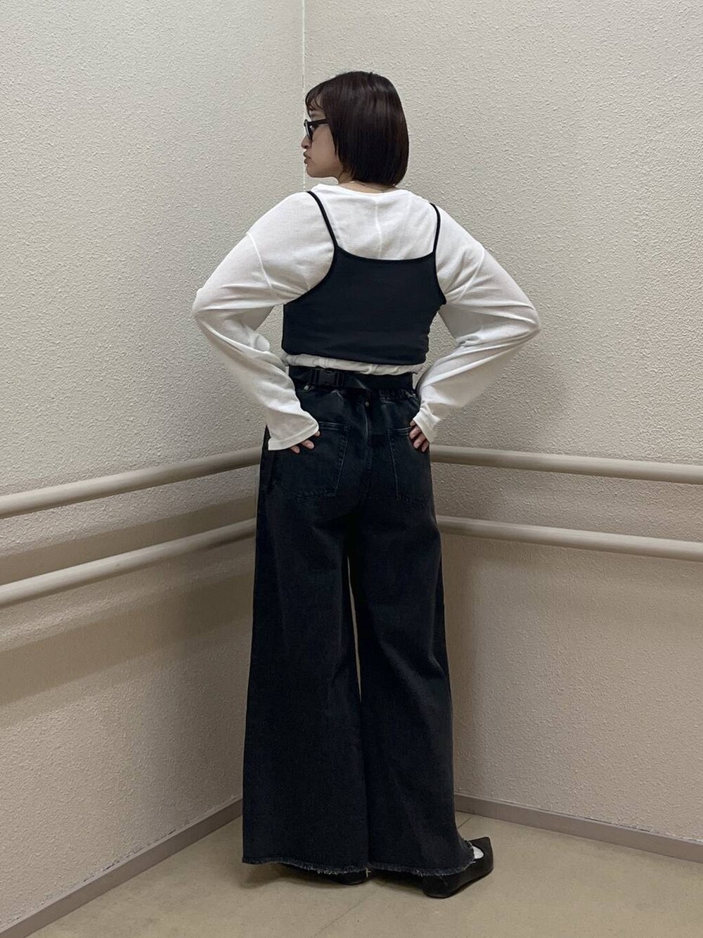 ホワイト系のTシャツ/カットソー、ブラック系のパンプス、ブラック系のデニムパンツを着用したレディースの春コーディネートの4枚目の写真