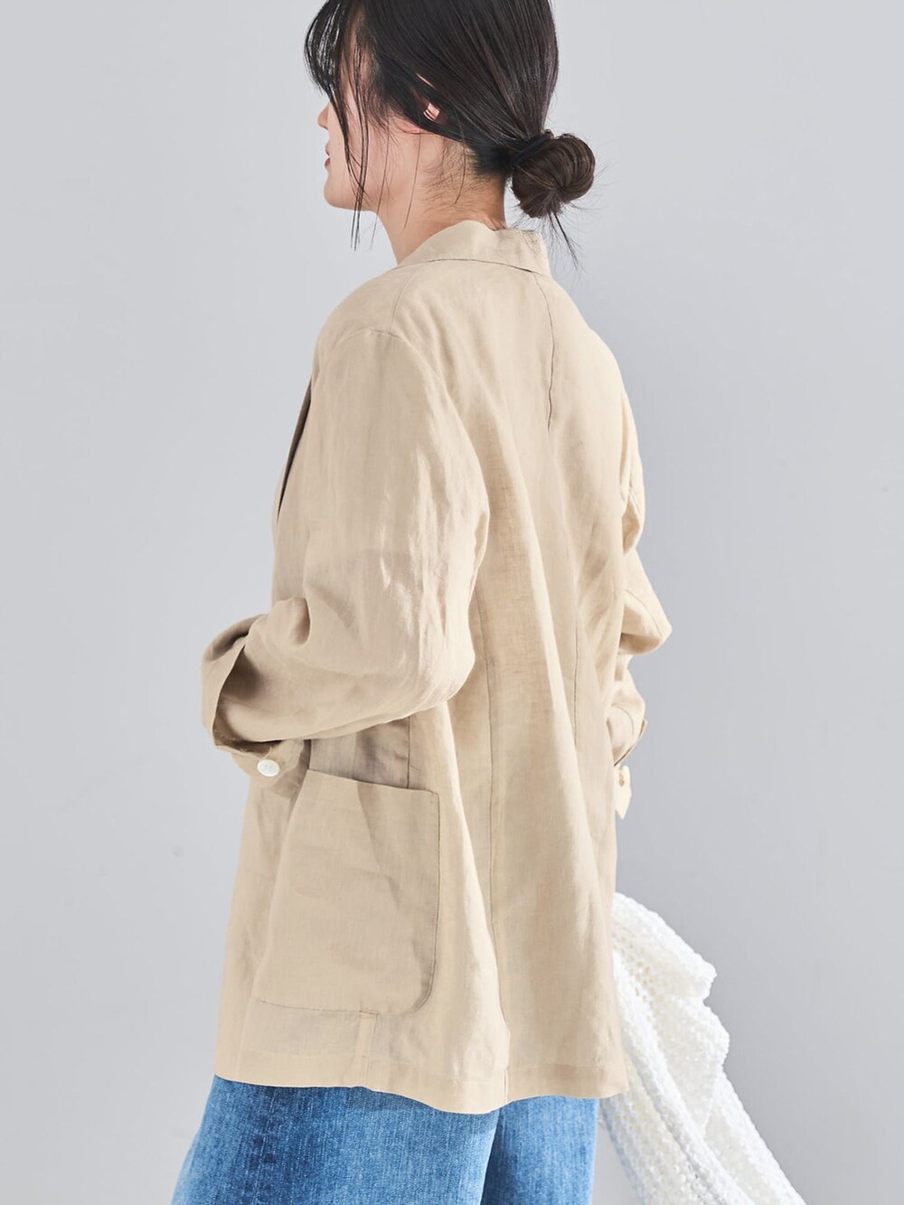 ベージュ系のテーラードジャケット、ブルー系のデニムパンツ、ホワイト系のTシャツ/カットソーを着用したレディースの春コーディネートの6枚目の写真