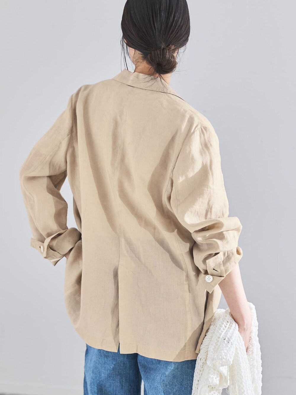 ベージュ系のテーラードジャケット、ブルー系のデニムパンツ、ホワイト系のTシャツ/カットソーを着用したレディースの春コーディネートの7枚目の写真
