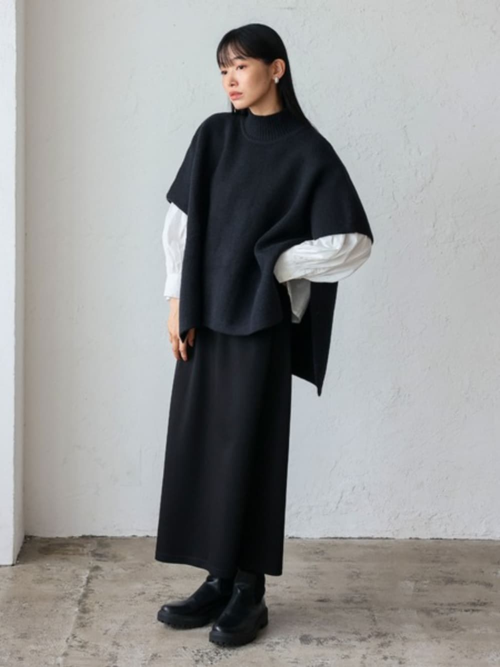 ブラック系のスカート、ブラック系のニット/セーターを着用したレディースの秋コーディネートの2枚目の写真