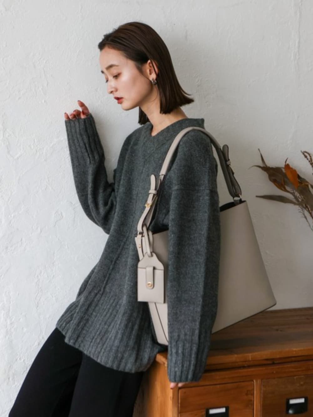 グレー系のニット/セーター、グレー系のトートバッグを着用したレディースの秋コーディネートの2枚目の写真
