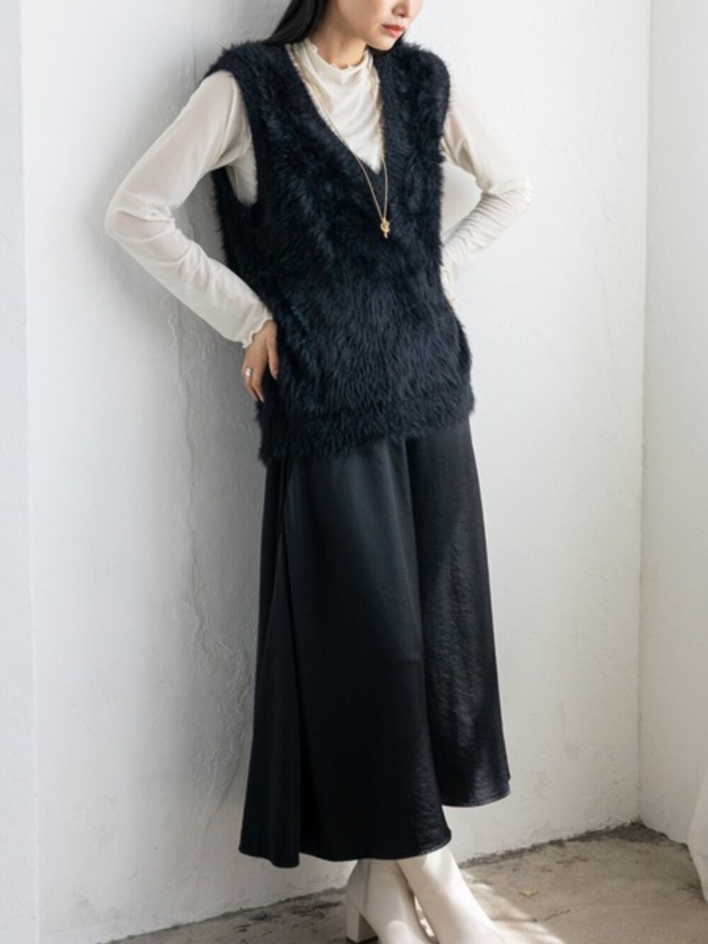 ブラック系のベストを着用したレディースの秋コーディネートの2枚目の写真