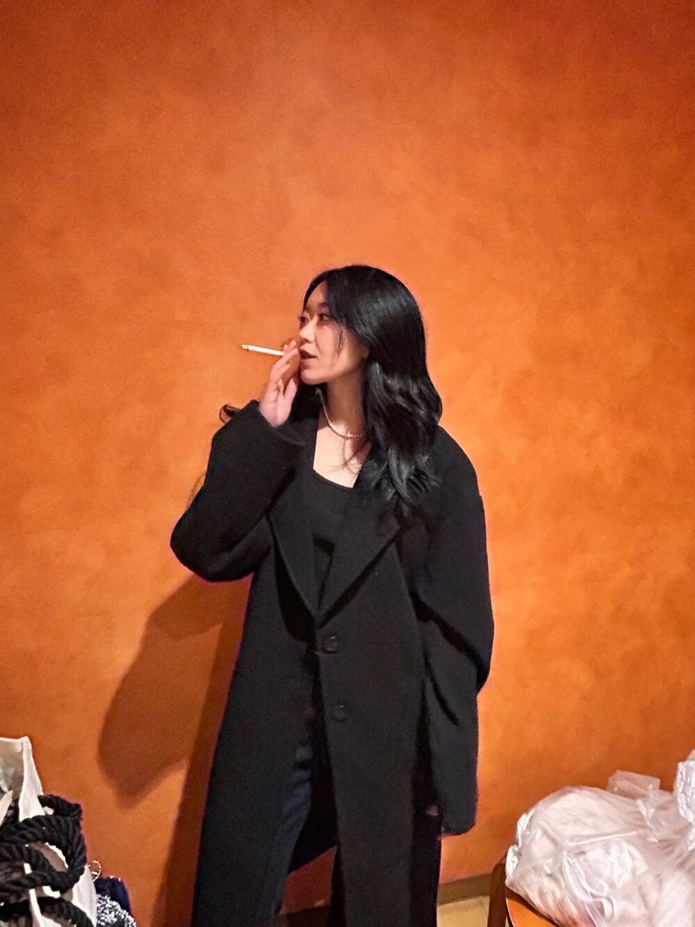 ブラック系のチェスターコートを着用したレディースの冬コーディネートの2枚目の写真