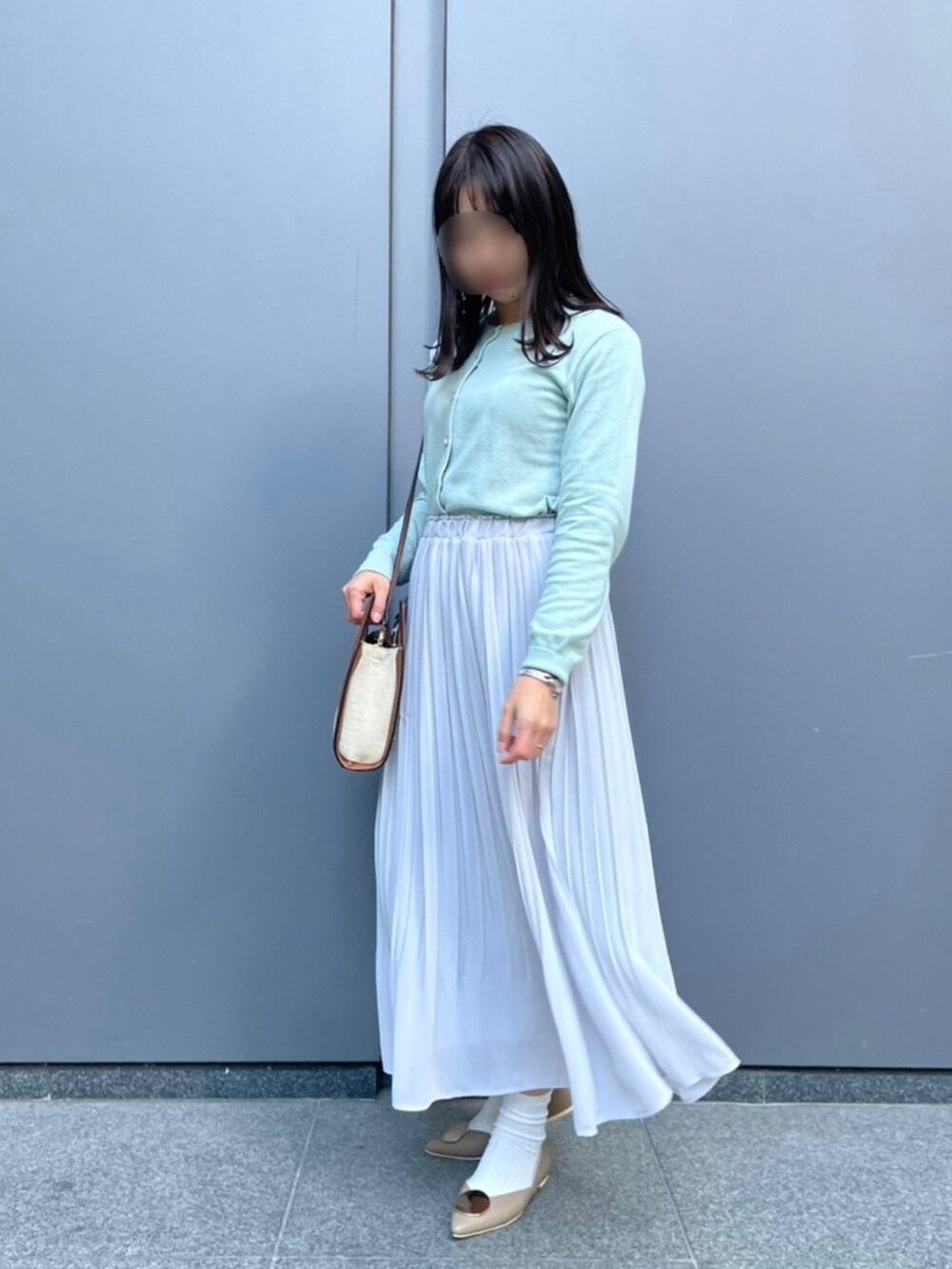 グレー系のスカート、ブルー系のカーディガン/ボレロ、イエロー系のショルダーバッグを着用したレディースの春コーディネートの2枚目の写真