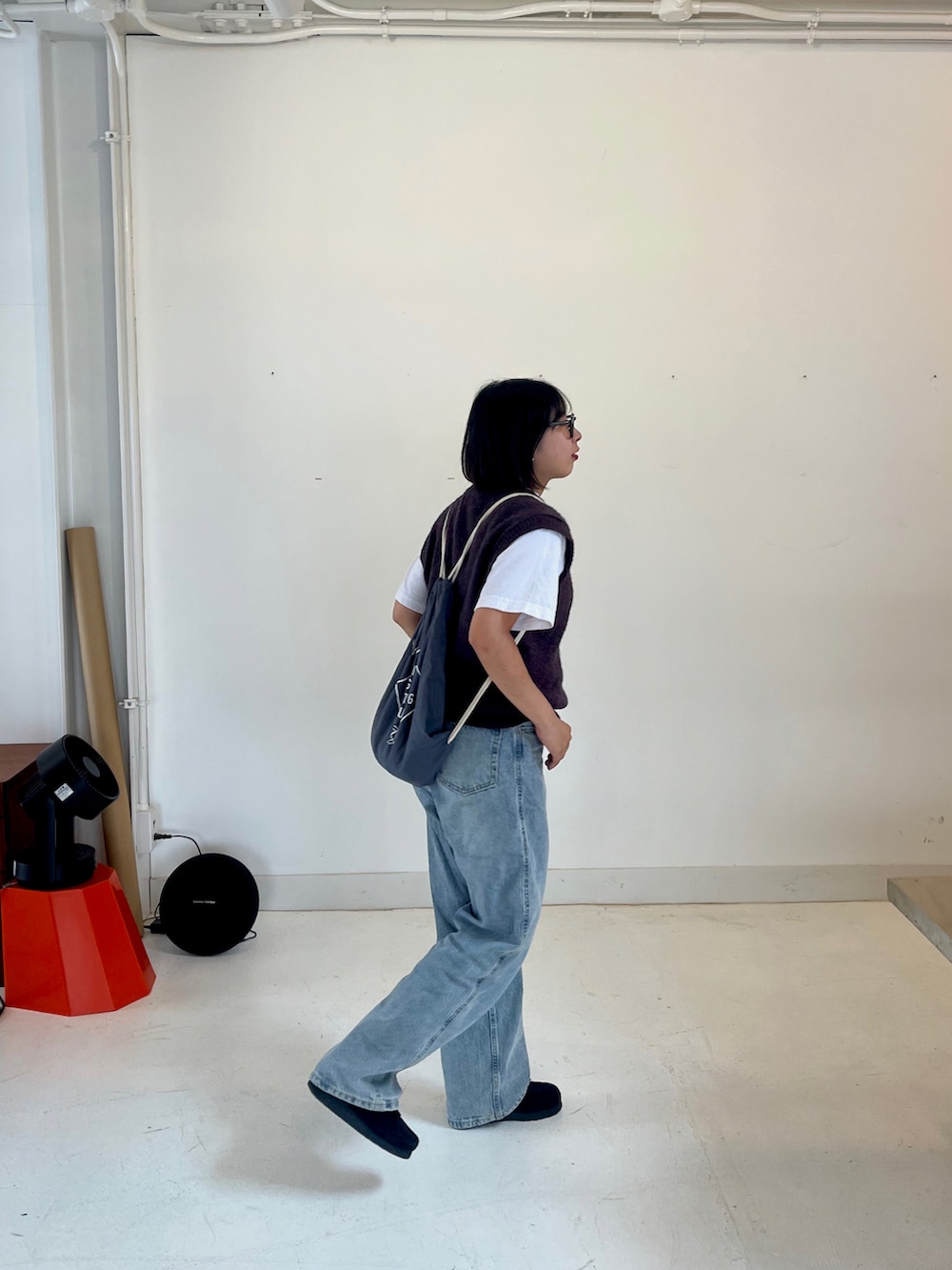 ブルー系のデニムパンツ、ブラック系のブーツ、ブラウン系のメガネを着用したレディースの秋コーディネートの2枚目の写真