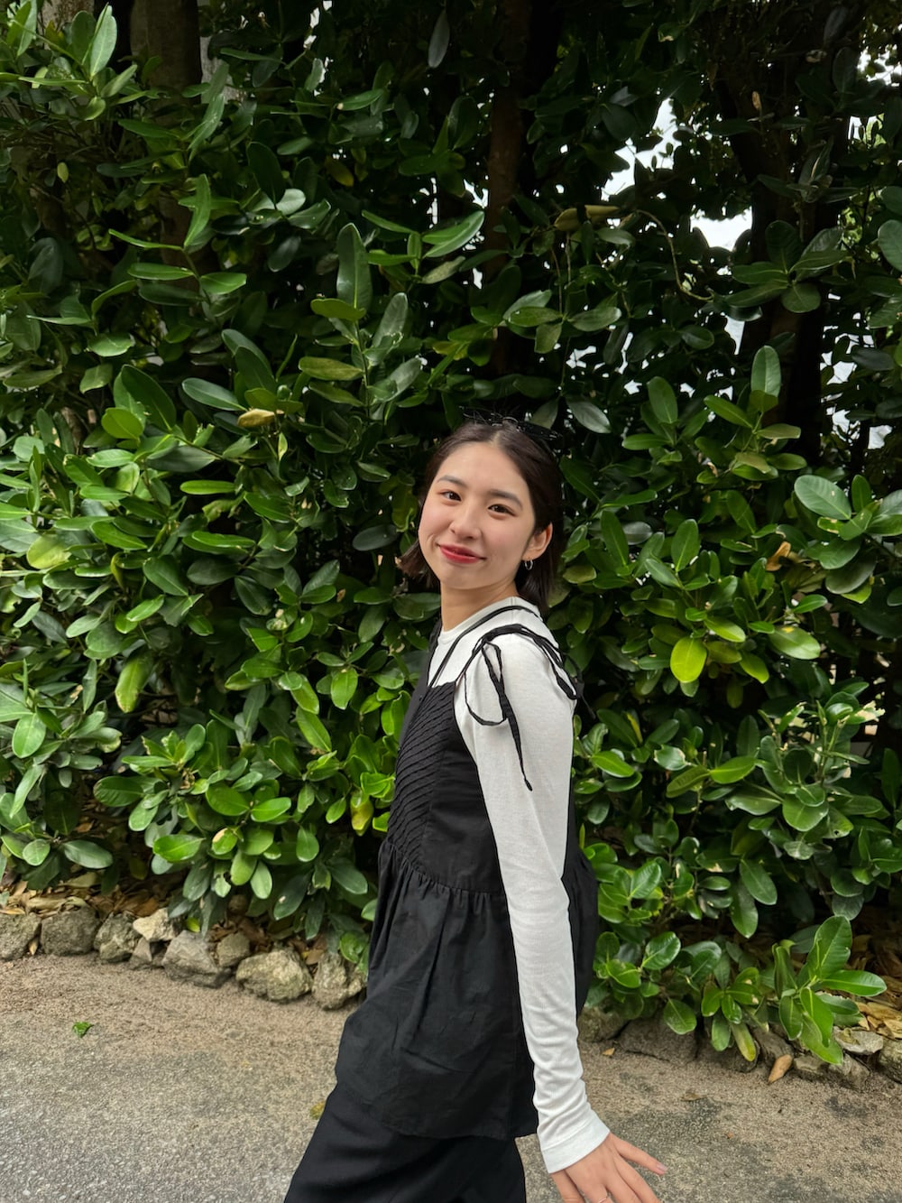 ブラック系のスラックス、ブラウン系のスニーカーを着用したレディースの春コーディネートの2枚目の写真