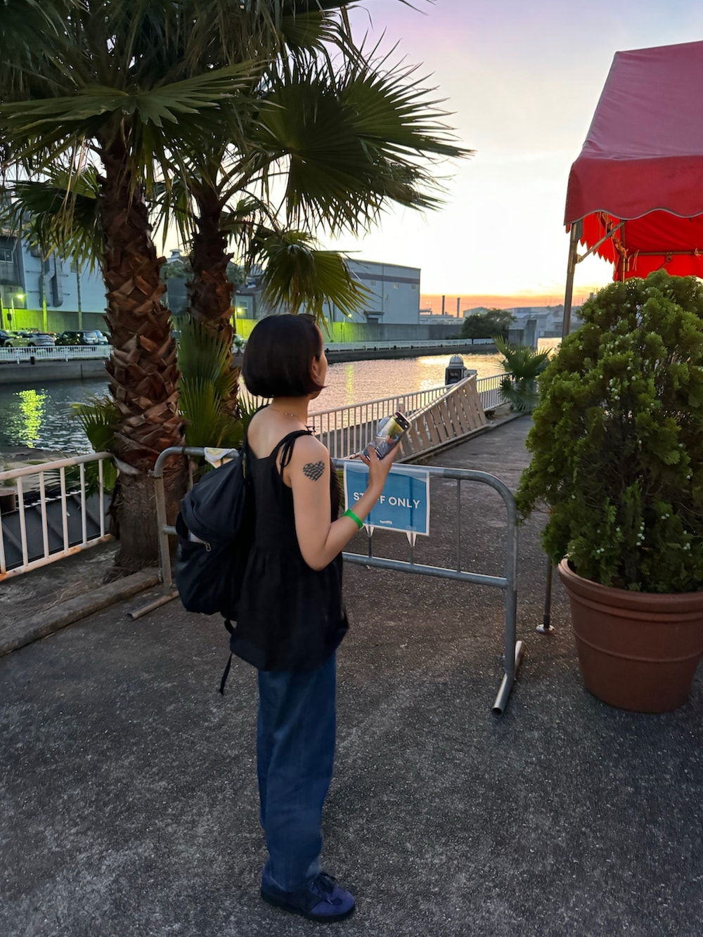 ブルー系のスニーカー、ブルー系のデニムパンツ、ブラック系のバックパック/リュックを着用したレディースの夏コーディネートの2枚目の写真