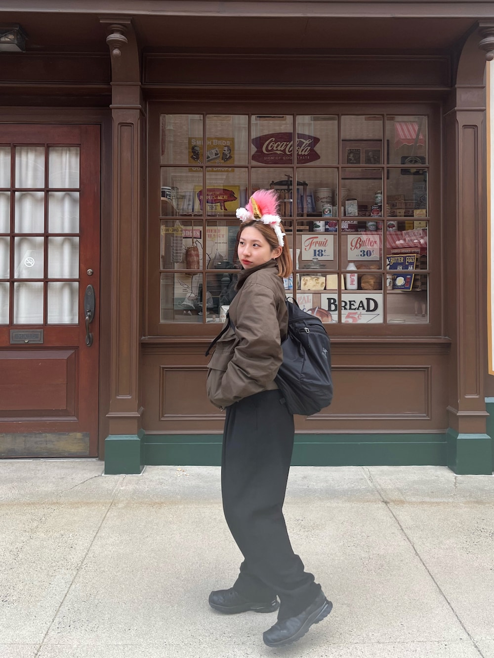 ブラック系のスニーカー、ブラック系のスラックス、ブラウン系のジャケット/アウターを着用したレディースの冬コーディネートの2枚目の写真