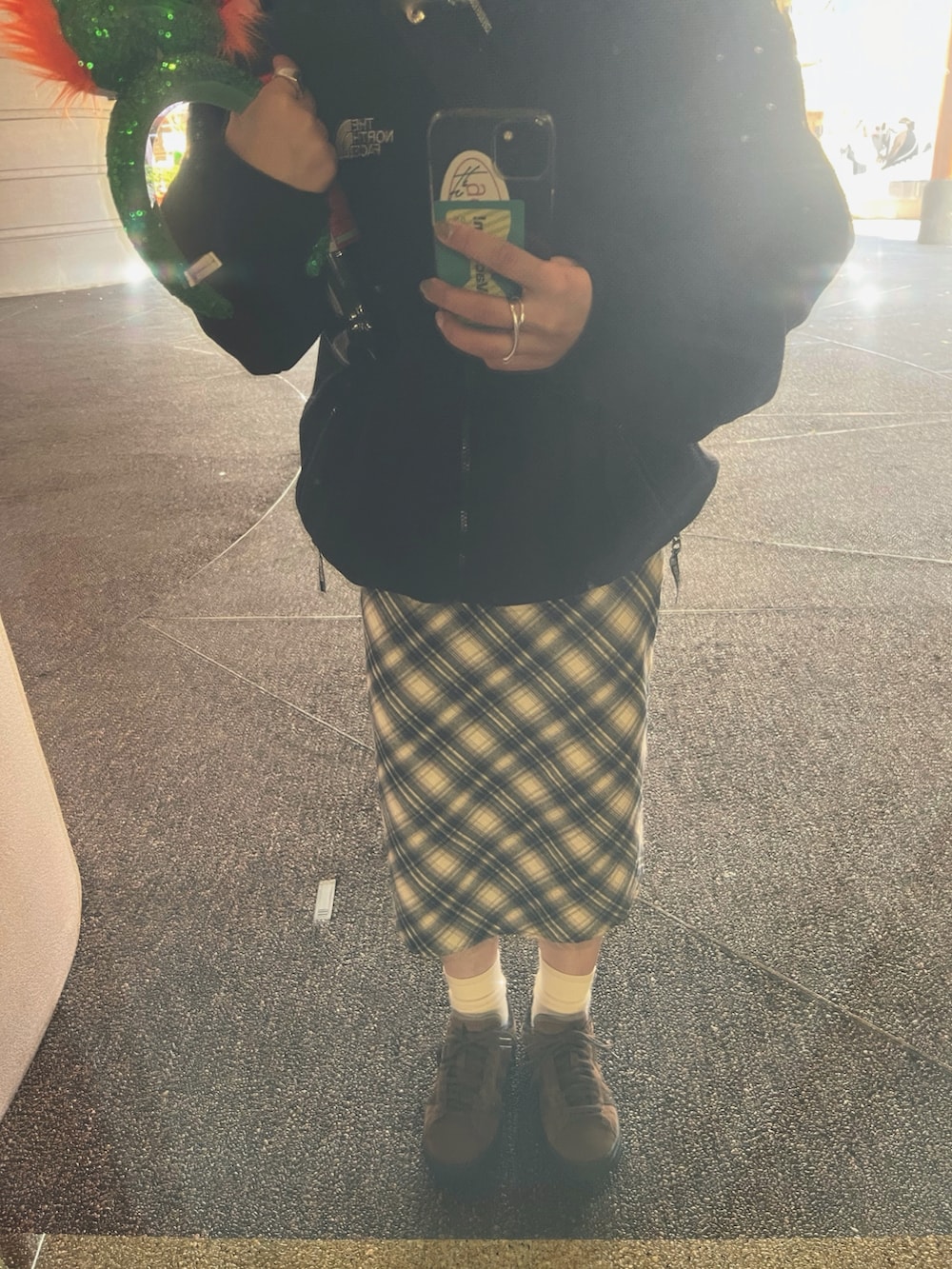 ブラック系のブルゾン、ホワイト系のショルダーバッグ、ブラウン系のスニーカーを着用したレディースの秋コーディネートの2枚目の写真