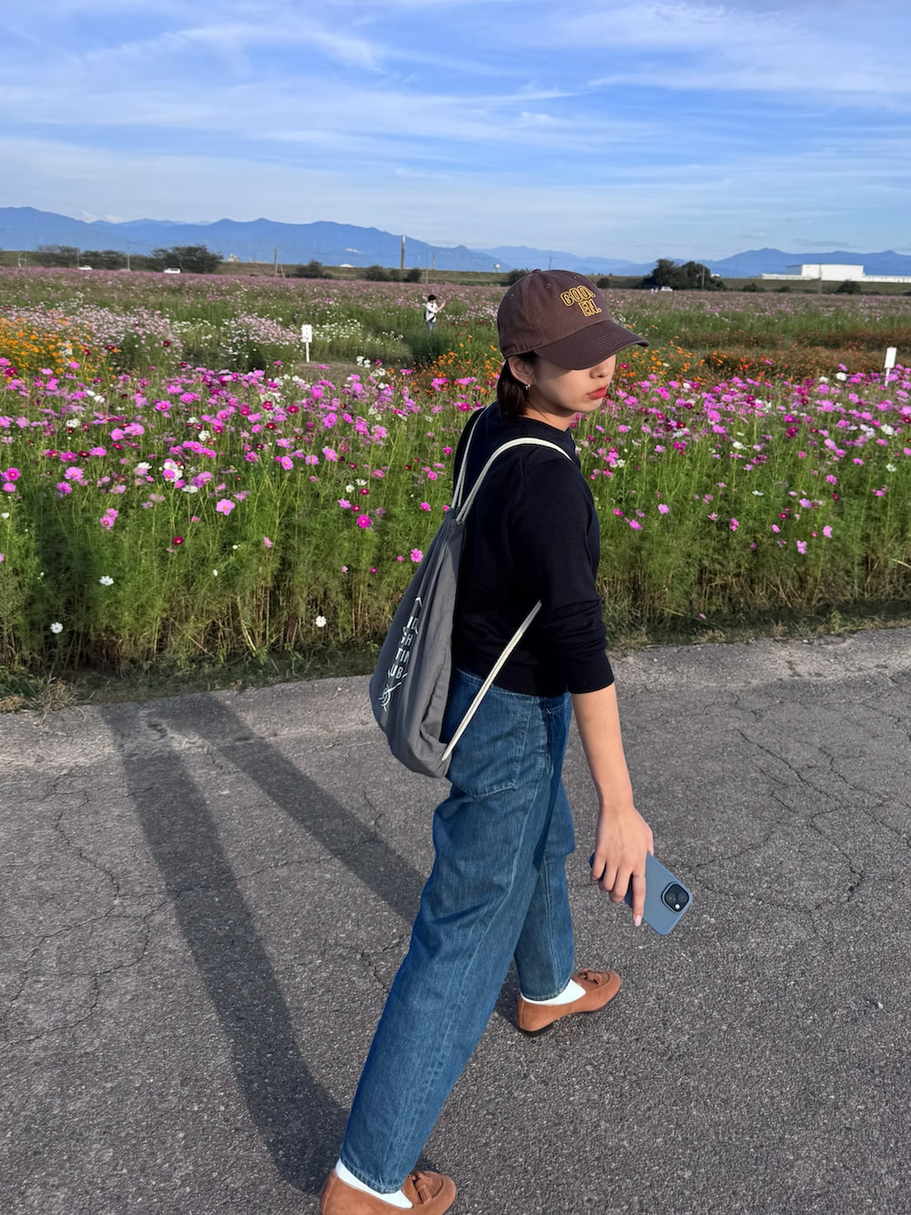 ブルー系のデニムパンツ、ブラウン系のローファー、ブルー系のカーディガン/ボレロを着用したレディースの秋コーディネートの2枚目の写真