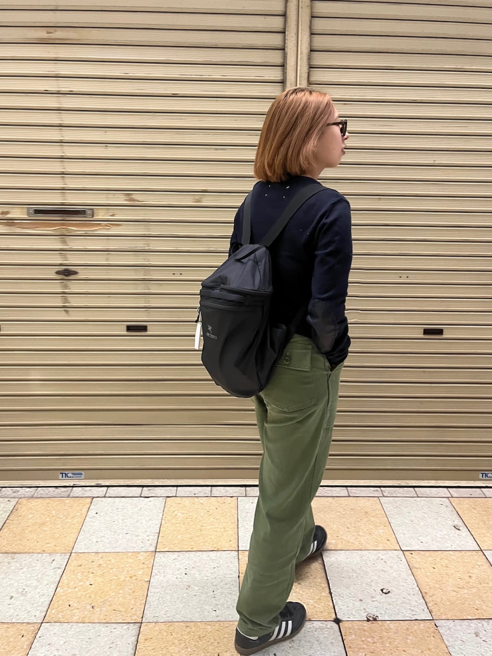 グリーン系のその他パンツ、ブラック系のスニーカー、ブルー系のニット/セーターを着用したレディースの秋コーディネートの2枚目の写真