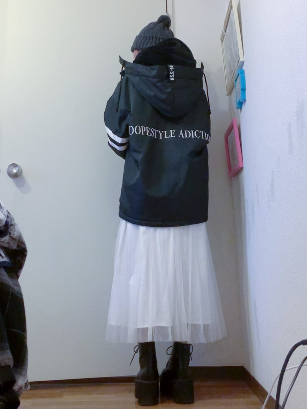 ブラック系のナイロンジャケット、ホワイト系のスカート、ブラック系のブーツを着用したレディースの秋コーディネートの3枚目の写真