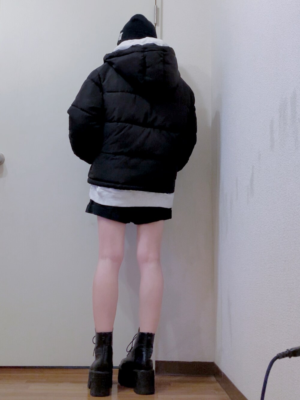 ブラック系のダウンジャケット/コート、グレー系のパーカー、ブラック系のデニムパンツを着用したレディースの冬コーディネートの2枚目の写真