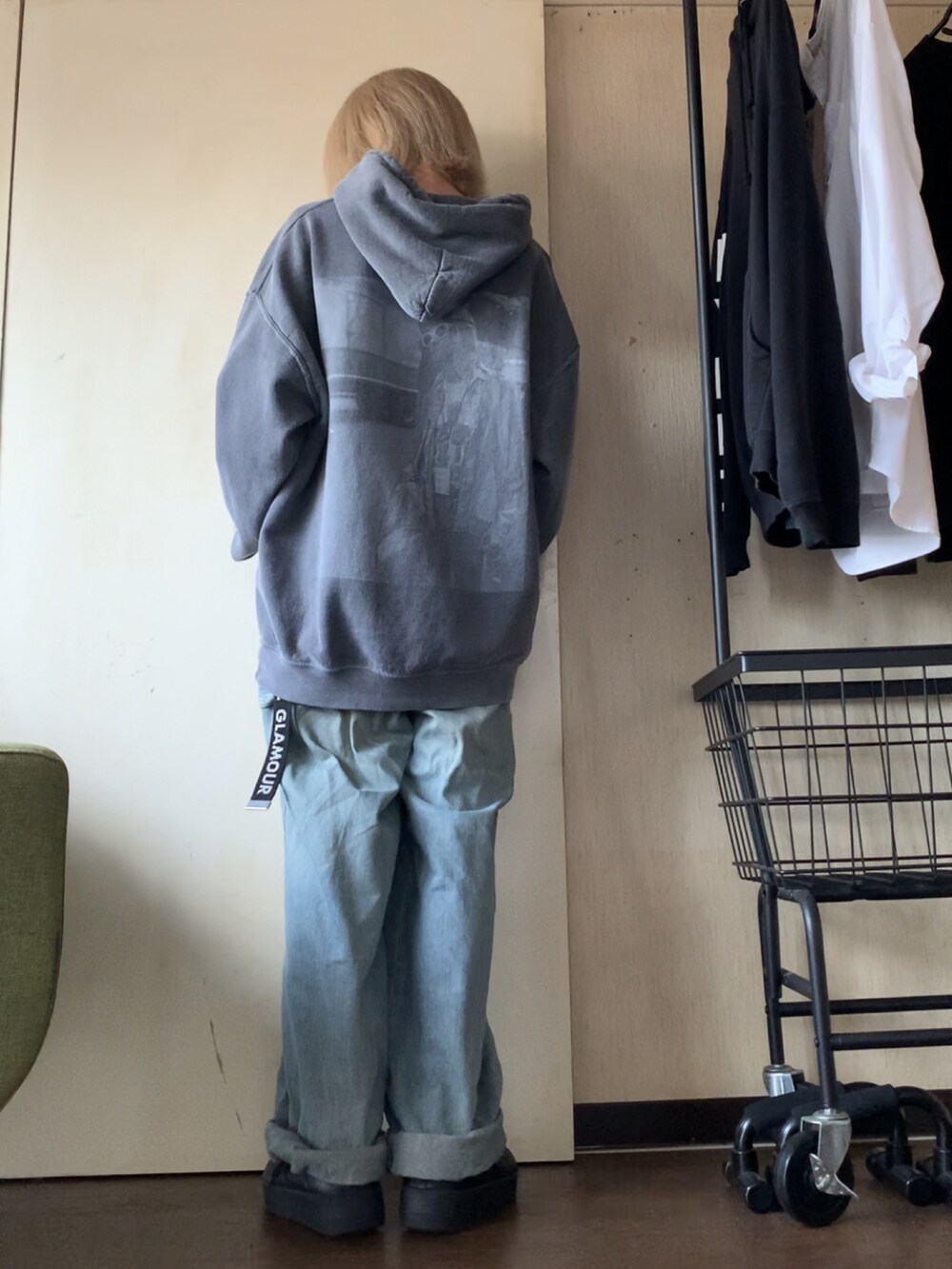 グレー系のパーカー、ブルー系のデニムパンツ、ブラック系のスニーカーを着用したレディースの秋コーディネートの2枚目の写真