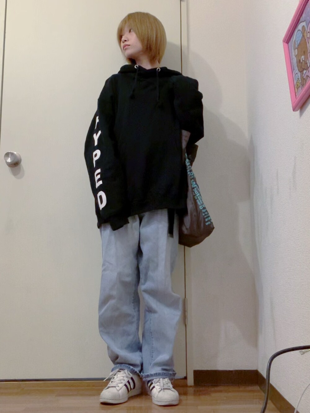 ブラック系のパーカー、ブルー系のデニムパンツ、ブラック系のナイロンジャケットを着用したレディースの冬コーディネートの3枚目の写真