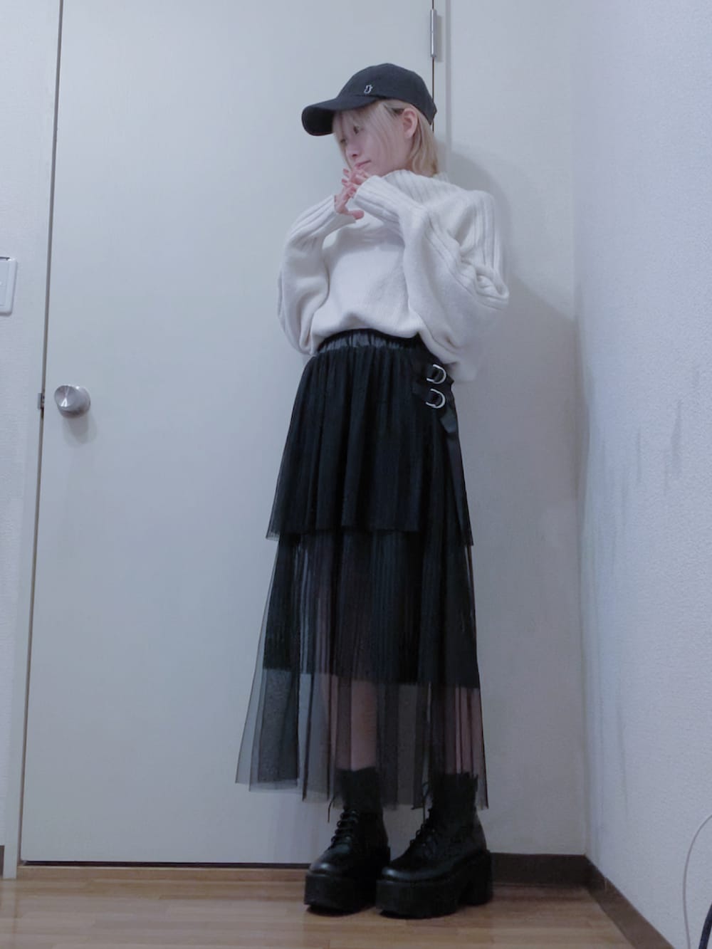 ホワイト系のニット/セーター、ブラック系のスカート、ブラック系のナイロンジャケットを着用したレディースの冬コーディネートの3枚目の写真