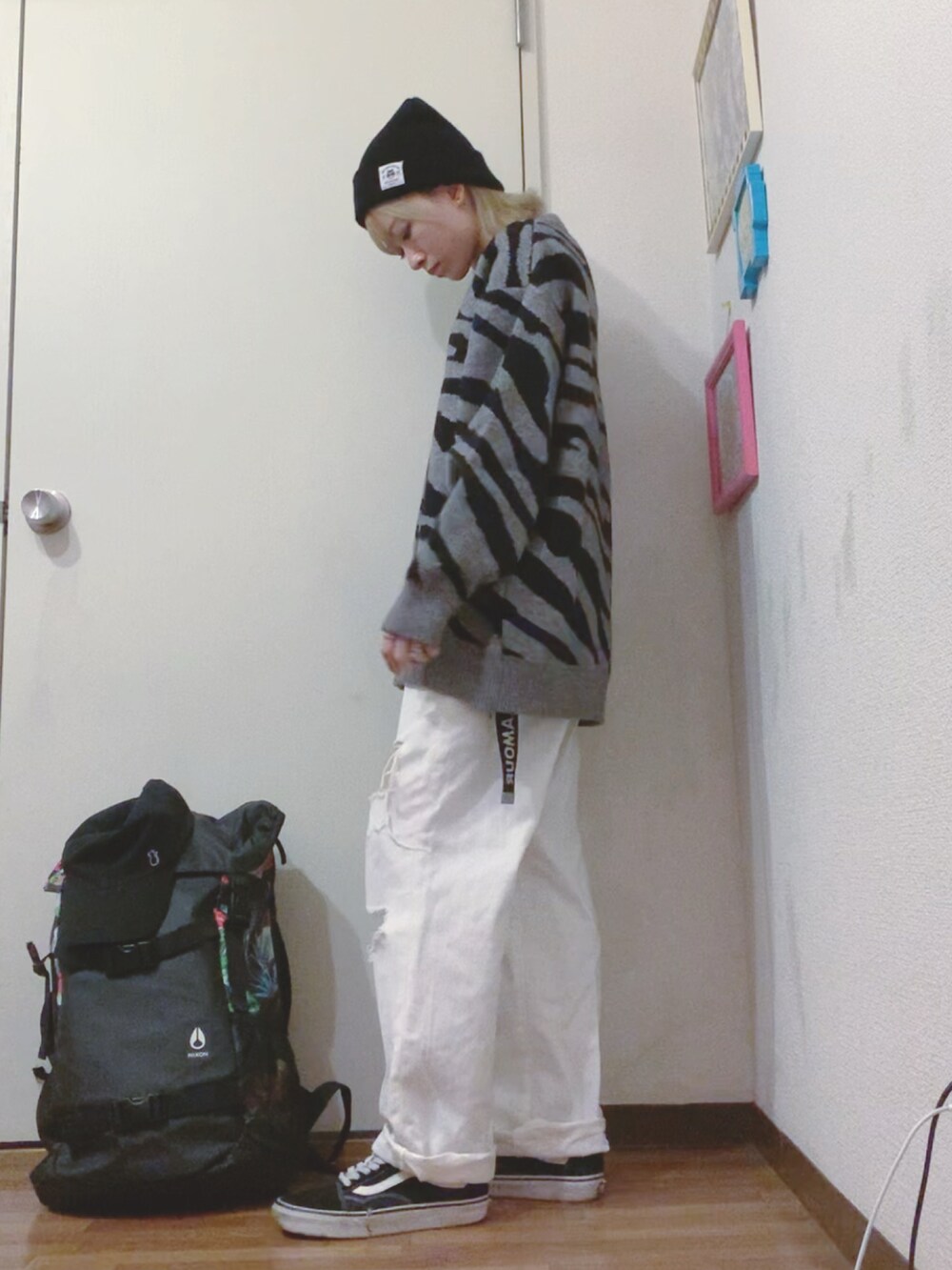 グレー系のニット/セーター、ホワイト系のデニムパンツ、ブラック系のスニーカーを着用したレディースの秋コーディネートの2枚目の写真