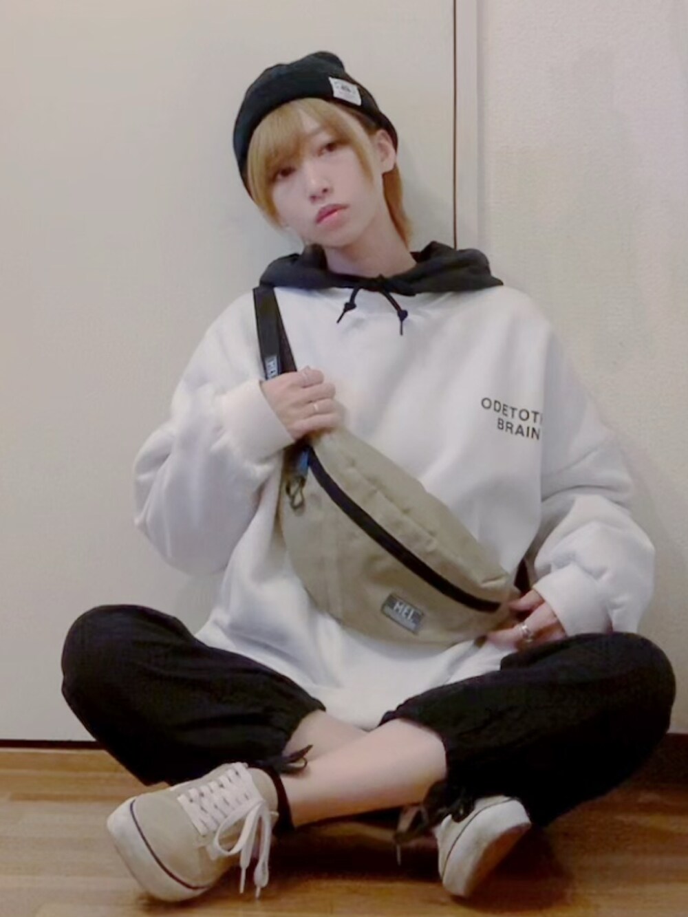 ホワイト系のスウェット、ブラック系のパーカー、ブラック系のカーゴパンツを着用したレディースの秋コーディネートの2枚目の写真