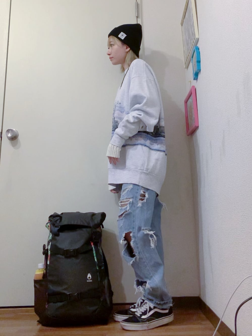 グレー系のスウェット、ブルー系のデニムパンツ、ブラック系のスニーカーを着用したレディースの秋コーディネートの2枚目の写真