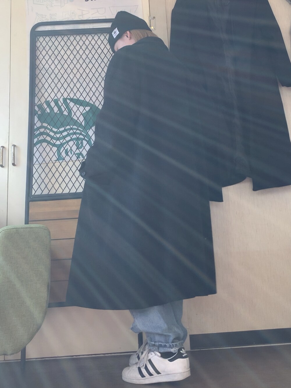 グレー系のチェスターコート、ホワイト系のスウェット、ブルー系のデニムパンツを着用したレディースの冬コーディネートの3枚目の写真