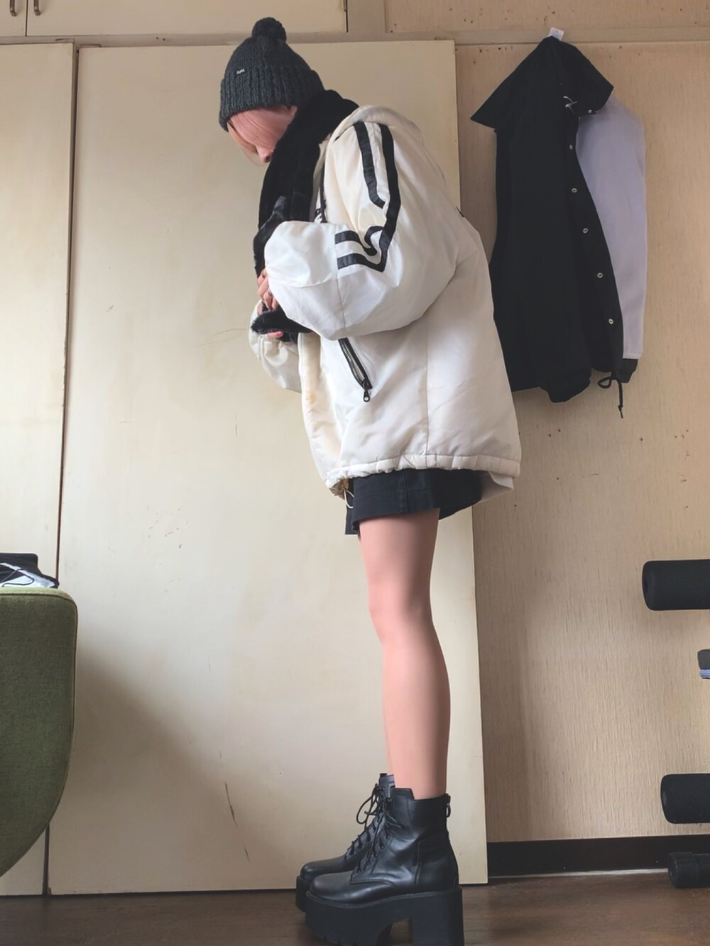 ホワイト系のブルゾン、ホワイト系のスウェット、ブラック系のスカートを着用したレディースの冬コーディネートの2枚目の写真