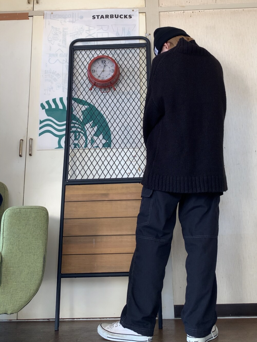 ブラック系のニット/セーター、ブラック系のカーゴパンツ、ベージュ系のダウンジャケット/コートを着用したレディースの冬コーディネートの4枚目の写真