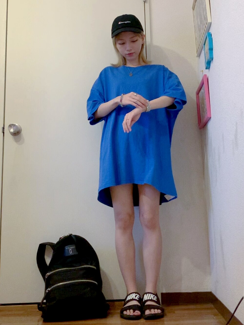 ブルー系のTシャツ/カットソー、ブラック系のサンダル、ブラック系のバックパック/リュックを着用したレディースの夏コーディネートの2枚目の写真