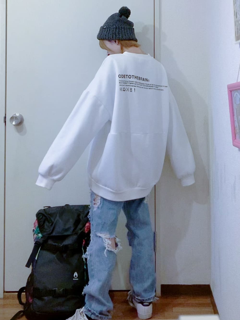 ホワイト系のスウェット、ホワイト系のブルゾン、ブルー系のデニムパンツを着用したレディースの秋コーディネートの3枚目の写真
