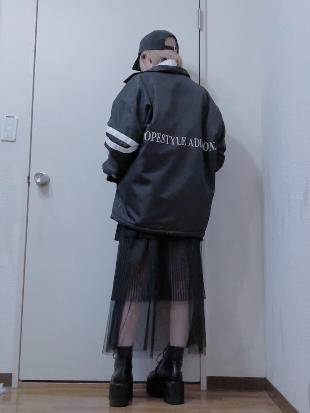 ホワイト系のニット/セーター、ブラック系のスカート、ブラック系のナイロンジャケットを着用したレディースの冬コーディネートの4枚目の写真