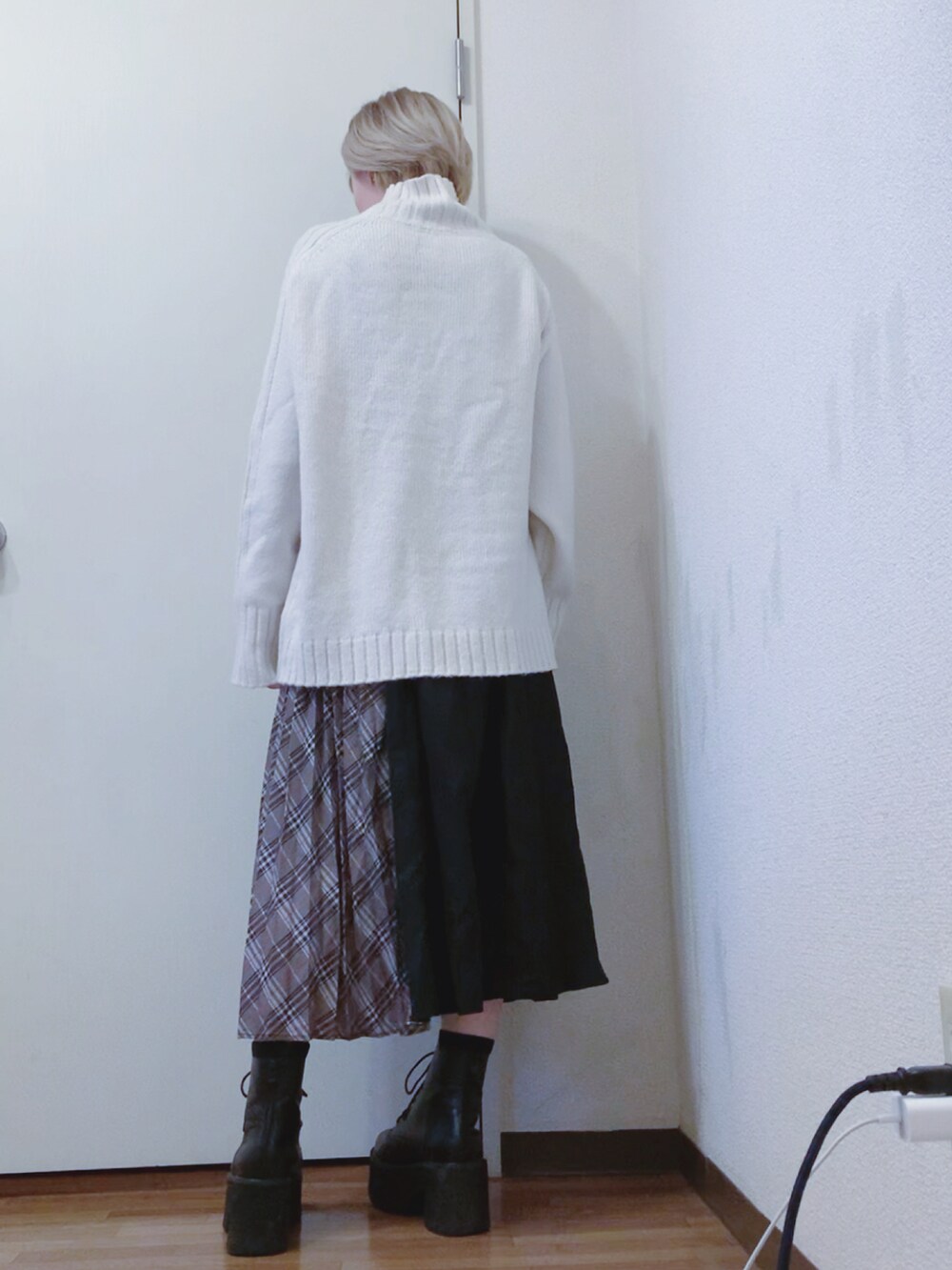 ホワイト系のニット/セーター、ブラック系のナイロンジャケット、ブラック系のスカートを着用したレディースの春コーディネートの4枚目の写真