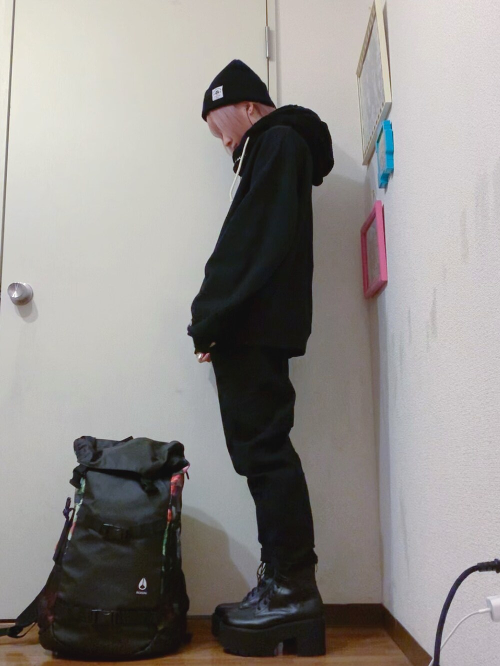 ブラック系のスウェット、ブラック系のデニムパンツ、ブラック系のブーツを着用したレディースの秋コーディネートの3枚目の写真