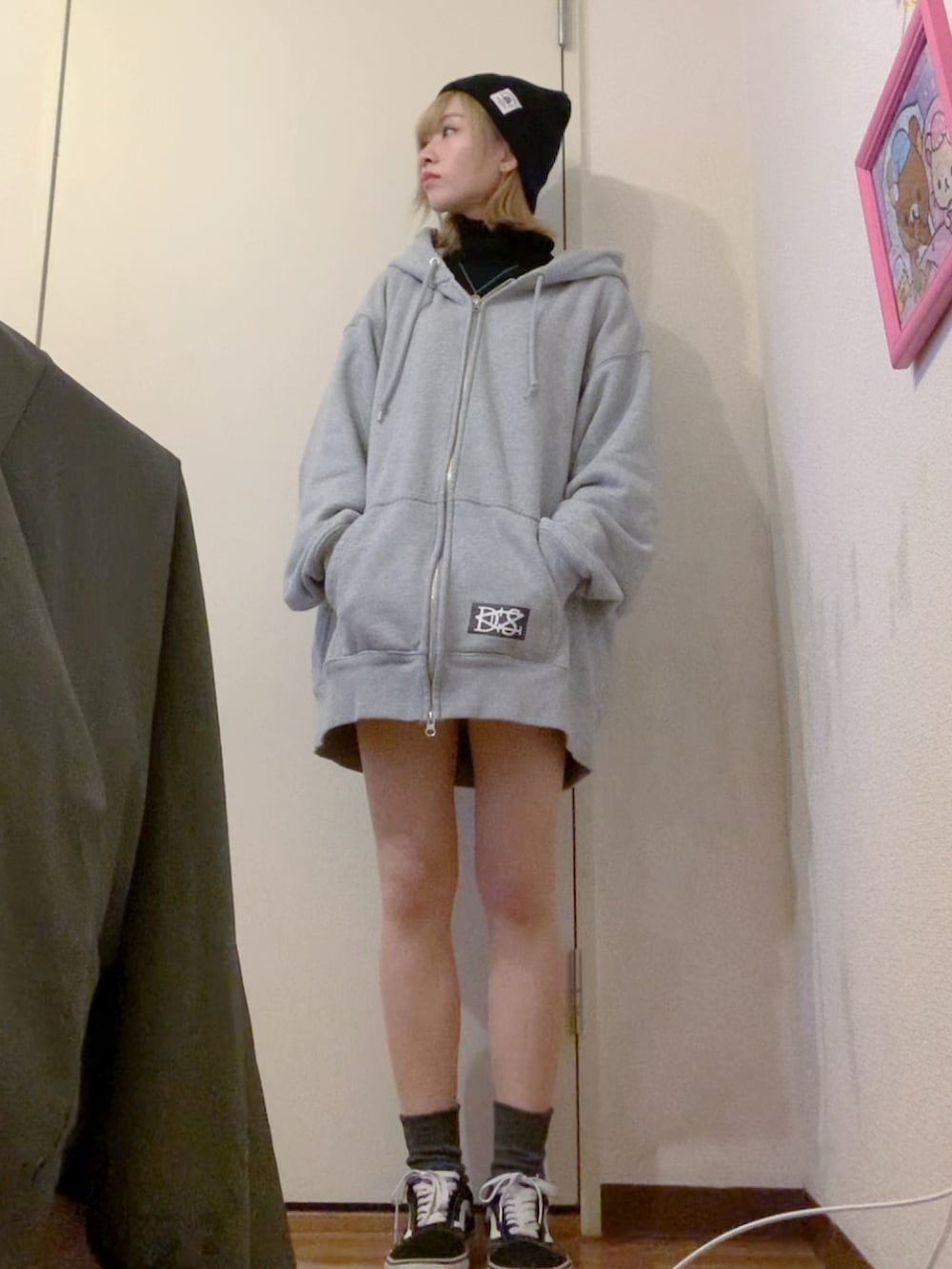 グレー系のパーカー、ブラック系のダウンジャケット/コート、ブラック系のニット/セーターを着用したレディースの冬コーディネートの2枚目の写真