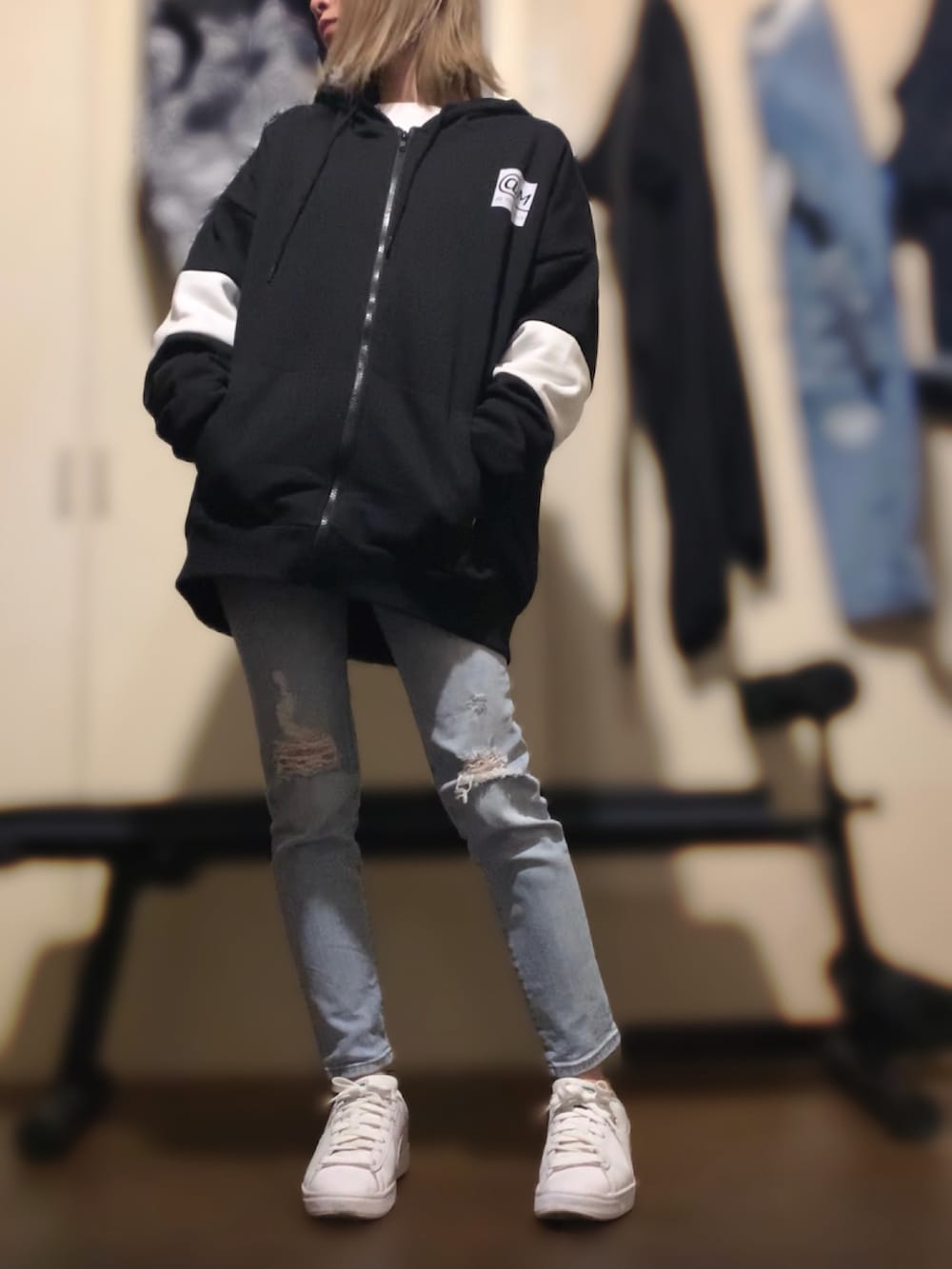 ブラック系のパーカー、ブルー系のデニムパンツ、ホワイト系のスニーカーを着用したレディースの冬コーディネートの3枚目の写真