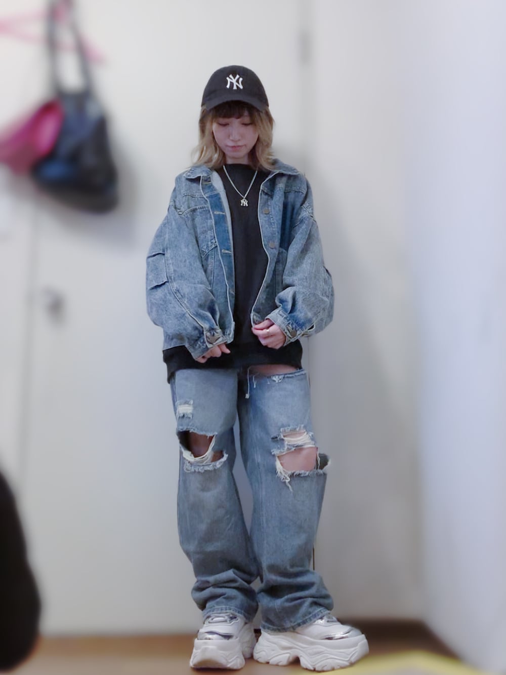 ブラック系のスウェット、ブルー系のデニムジャケット、ブルー系のデニムパンツを着用したレディースの春コーディネートの2枚目の写真