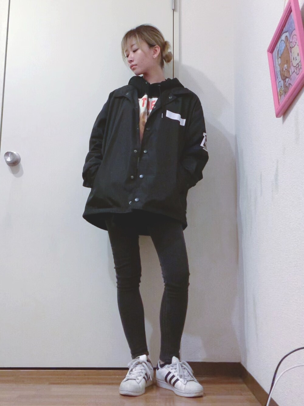 ブラック系のパーカー、ブラック系のデニムパンツ、ブラック系のナイロンジャケットを着用したレディースの春コーディネートの4枚目の写真