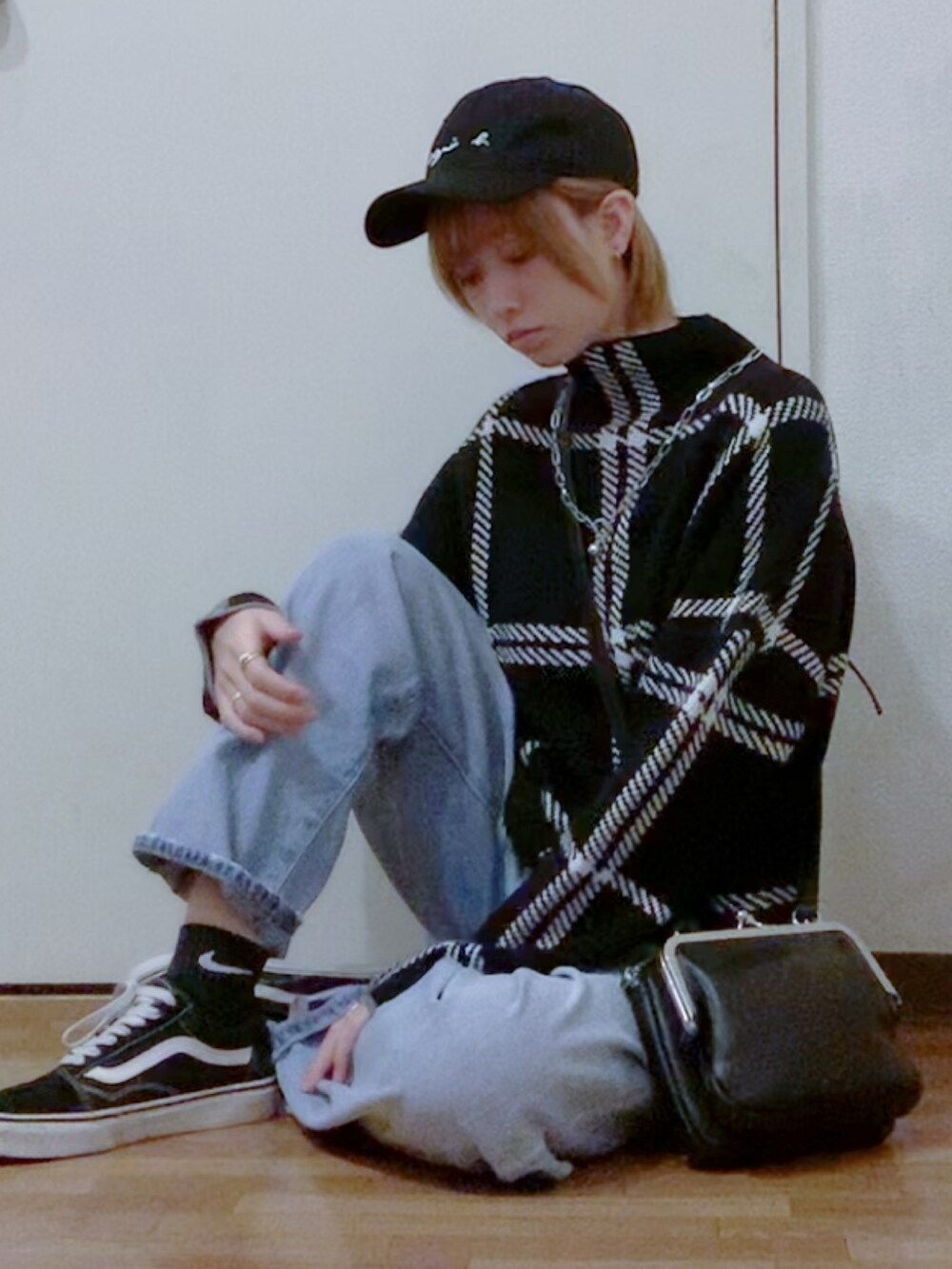 ブラック系のニット/セーター、ブルー系のデニムパンツ、ブラック系のダウンジャケット/コートを着用したレディースの秋コーディネートの2枚目の写真