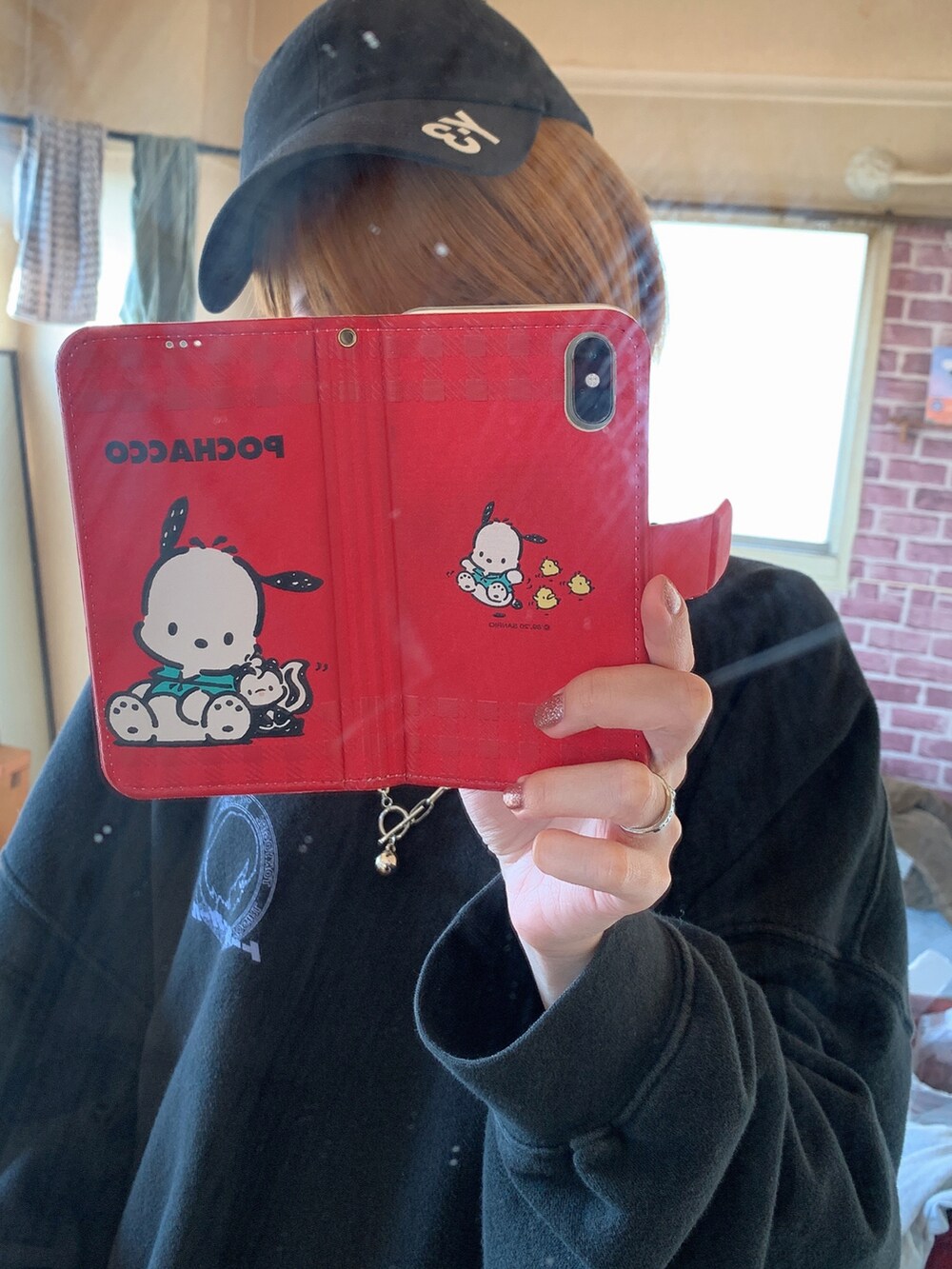 ブラック系のスウェット、レッド系のスウェットパンツ、ホワイト系のスニーカーを着用したレディースの冬コーディネートの5枚目の写真